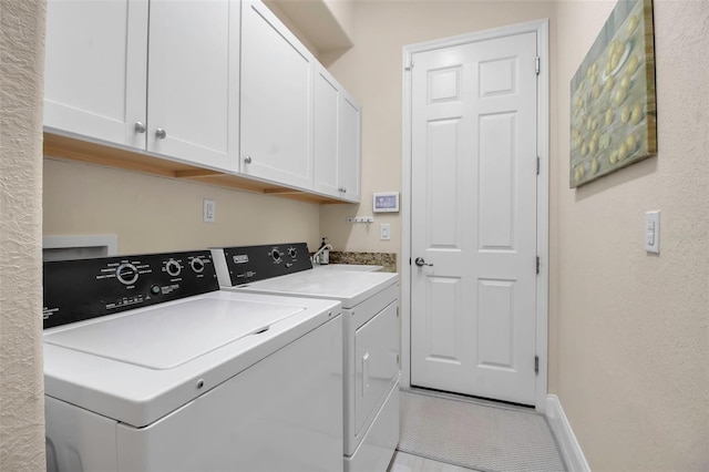 washroom with cabinets and washer and clothes dryer