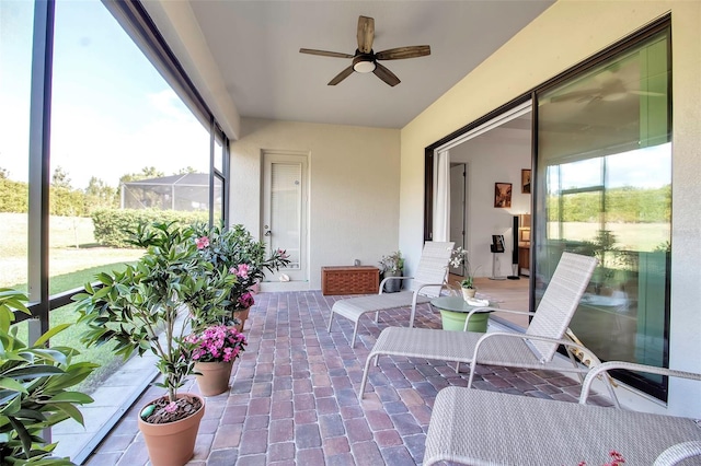 sunroom / solarium with ceiling fan and a healthy amount of sunlight