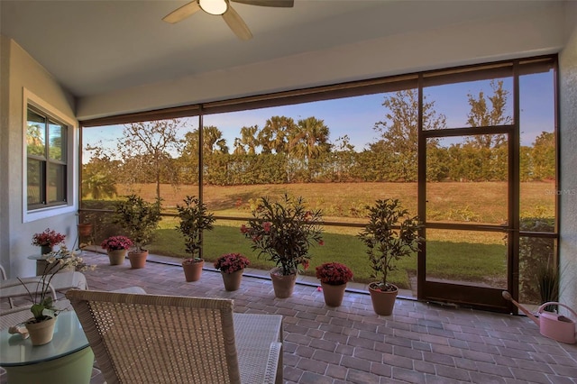 unfurnished sunroom with ceiling fan