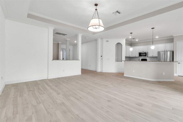 13303 Swiftwater Way, Lakewood Ranch, FL 34211 - unfurnished living room with crown molding, recessed lighting, baseboards, light wood-style floors, and arched walkways