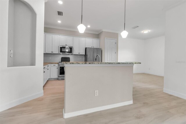 13303 Swiftwater Way, Lakewood Ranch, FL 34211 - kitchen featuring appliances with stainless steel finishes, white cabinets, an island with sink, light wood finished floors, and crown molding