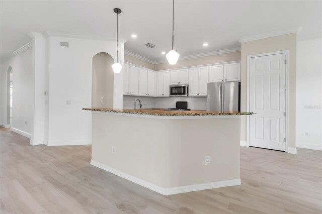 13303 Swiftwater Way, Lakewood Ranch, FL 34211 - kitchen with appliances with stainless steel finishes, ornamental molding, a sink, dark stone counters, and white cabinetry