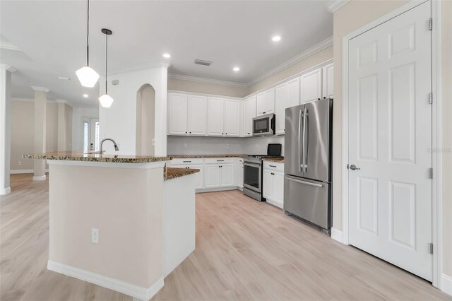 13303 Swiftwater Way, Lakewood Ranch, FL 34211 - kitchen with appliances with stainless steel finishes, white cabinets, crown molding, light wood-style flooring, and dark stone countertops