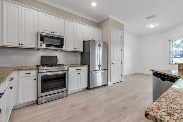 13303 Swiftwater Way, Lakewood Ranch, FL 34211 - kitchen featuring stainless steel appliances, white cabinets, ornamental molding, decorative backsplash, and light stone countertops