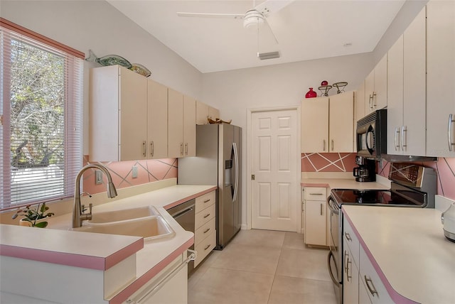 kitchen featuring sink, light tile patterned floors, a wealth of natural light, and stainless steel appliances