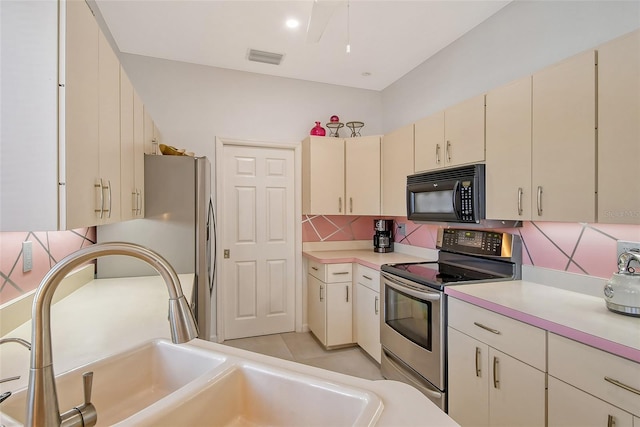 kitchen with backsplash, stainless steel appliances, sink, and cream cabinetry