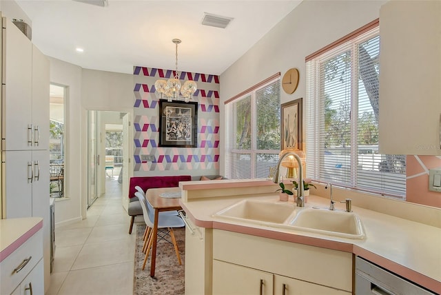 kitchen with sink, white cabinetry, decorative light fixtures, light tile patterned floors, and dishwashing machine