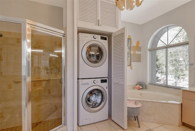 clothes washing area with stacked washer and dryer and light tile patterned floors