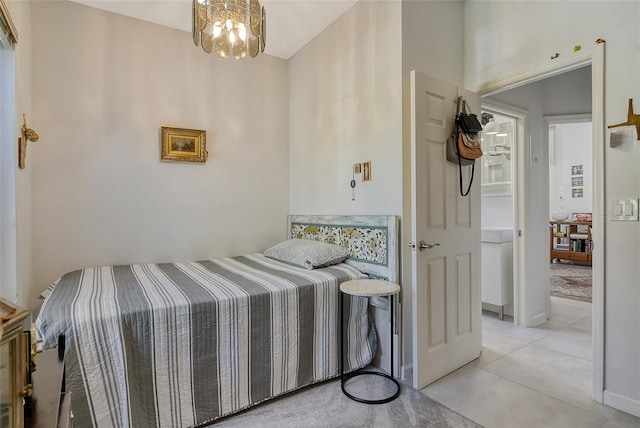 bedroom with an inviting chandelier and light tile patterned flooring