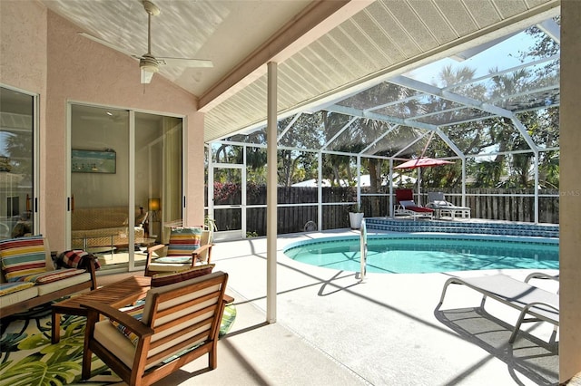 view of pool featuring a patio, outdoor lounge area, and glass enclosure