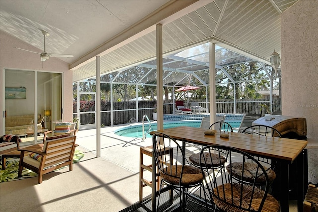 sunroom with ceiling fan, vaulted ceiling, and a swimming pool