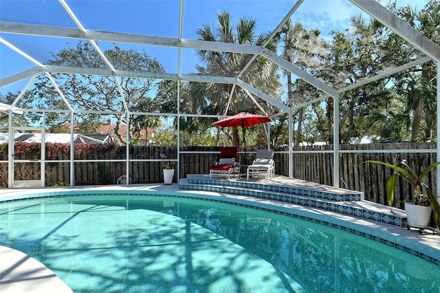 view of pool with a patio area and glass enclosure