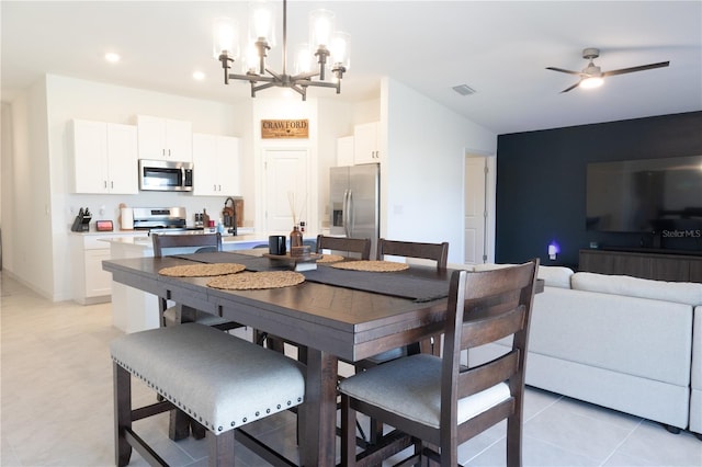 dining space with light tile patterned floors, recessed lighting, visible vents, and ceiling fan with notable chandelier