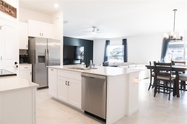 kitchen with a sink, stainless steel appliances, light countertops, and white cabinetry