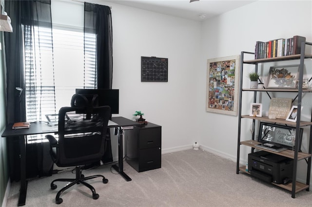 home office featuring light carpet, plenty of natural light, and baseboards