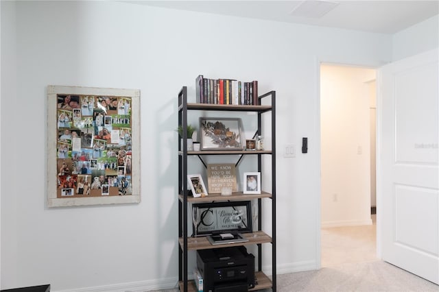 hall with light carpet, visible vents, and baseboards