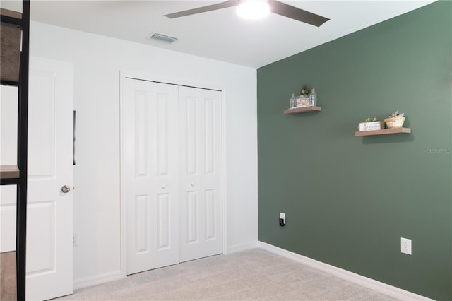 unfurnished bedroom featuring light carpet, baseboards, visible vents, and a closet