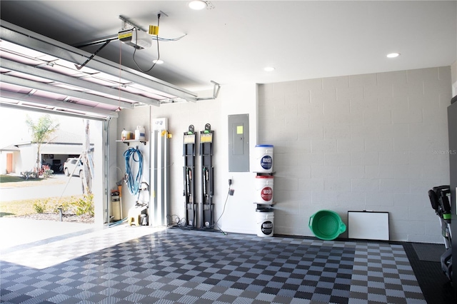 garage with recessed lighting, electric panel, and a garage door opener