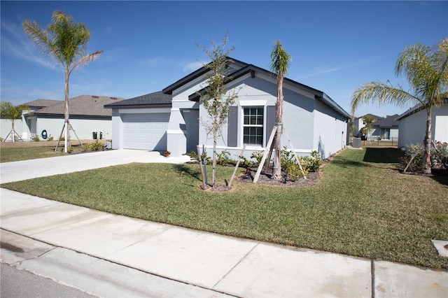 ranch-style home featuring a front yard, concrete driveway, and stucco siding