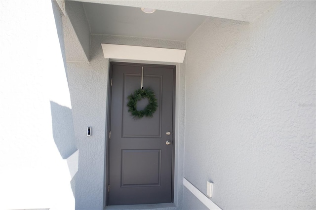 view of exterior entry with stucco siding