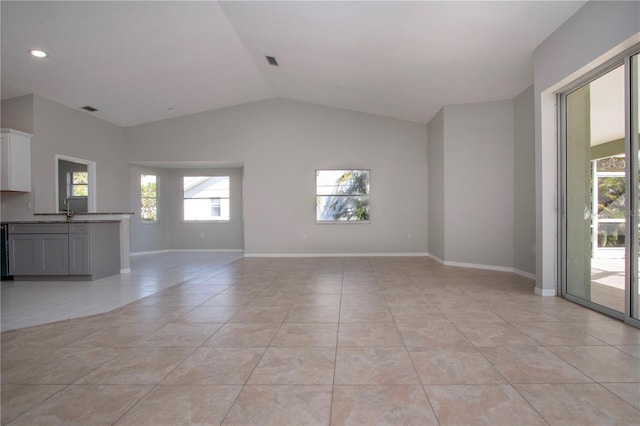 unfurnished living room with light tile patterned flooring and lofted ceiling