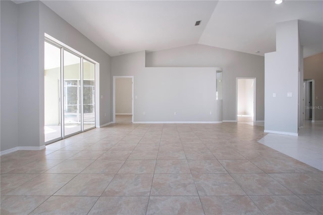 unfurnished room with lofted ceiling and light tile patterned flooring