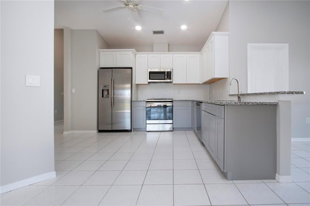 kitchen featuring sink, appliances with stainless steel finishes, light stone countertops, white cabinets, and decorative backsplash