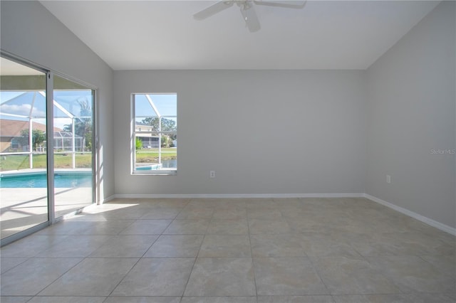 tiled empty room featuring vaulted ceiling and ceiling fan