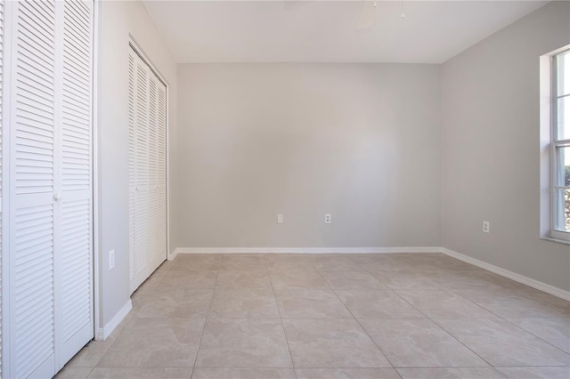 unfurnished bedroom with multiple windows and light tile patterned floors