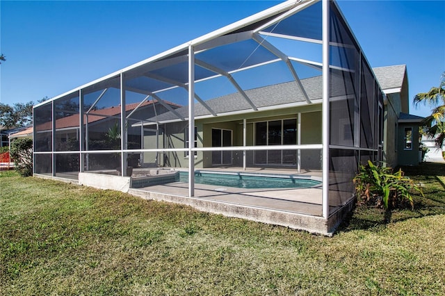 rear view of property with a lanai, a patio area, and a lawn