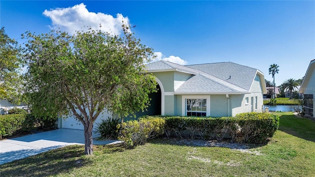 view of front facade featuring a garage, a water view, and a front yard