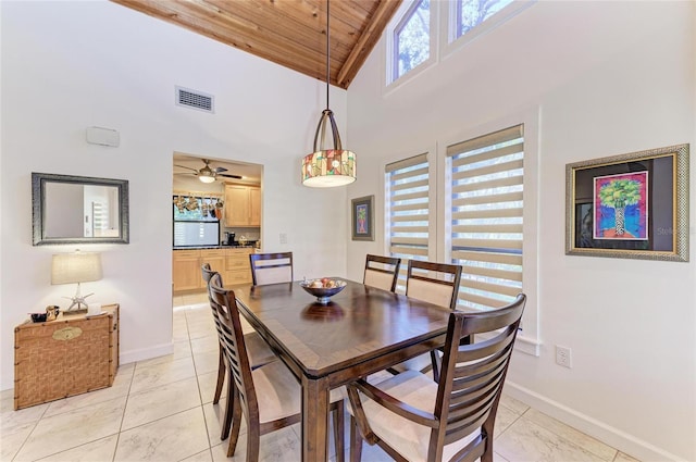 tiled dining space with high vaulted ceiling and wood ceiling