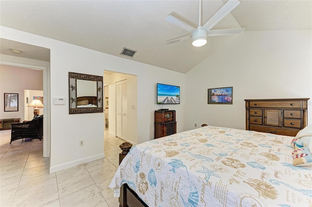 bedroom with lofted ceiling, a textured ceiling, and a closet