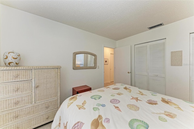 bedroom with a textured ceiling and a closet