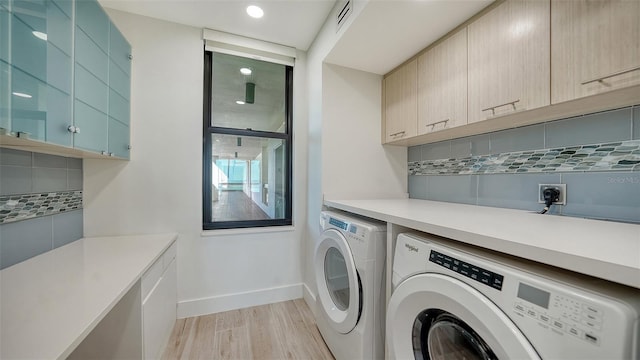 laundry area featuring cabinet space, visible vents, baseboards, independent washer and dryer, and light wood-style floors