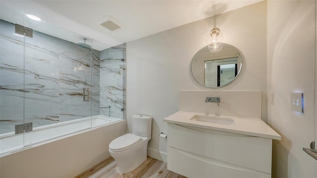 full bath featuring visible vents, toilet, wood finished floors, a combined bath / shower with rainfall shower, and vanity