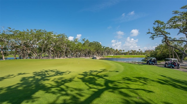 view of home's community featuring a water view, golf course view, and a lawn