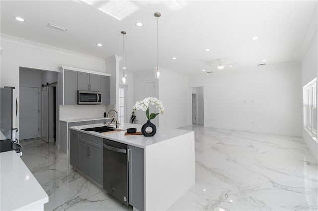 kitchen featuring gray cabinets, an island with sink, sink, hanging light fixtures, and stainless steel appliances