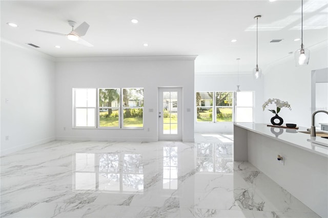 unfurnished living room featuring crown molding, a healthy amount of sunlight, and ceiling fan