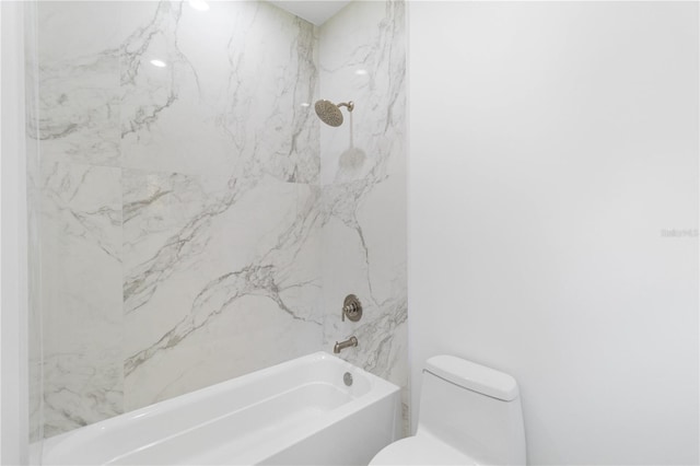 bathroom featuring tiled shower / bath and toilet