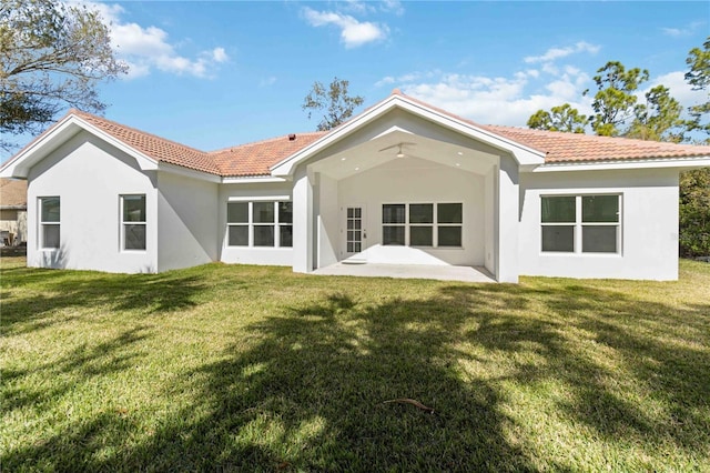 back of house with a patio area and a lawn