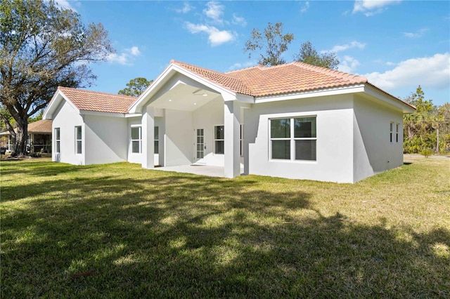 rear view of property featuring a patio area and a lawn