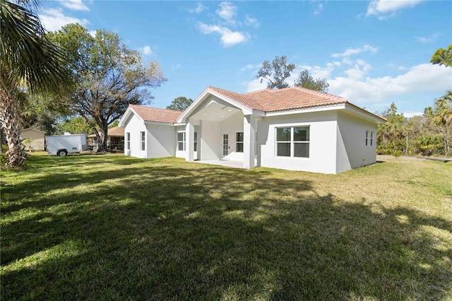 back of property featuring a patio area and a lawn