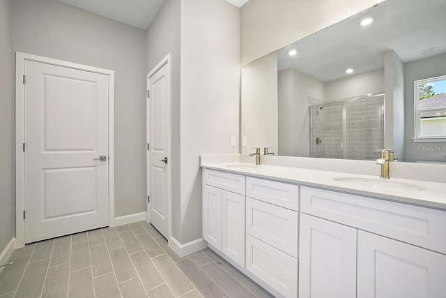 bathroom with vanity and a shower with shower door