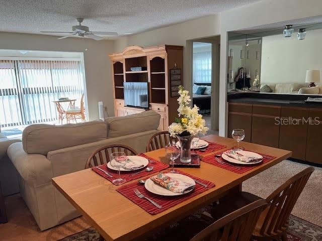 dining space featuring ceiling fan and a textured ceiling