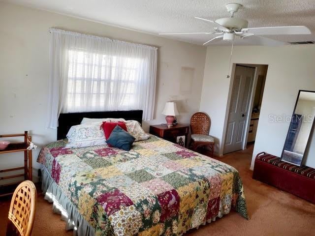 bedroom featuring ceiling fan and a textured ceiling