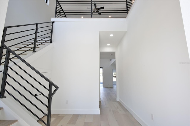 stairs featuring hardwood / wood-style floors and a towering ceiling