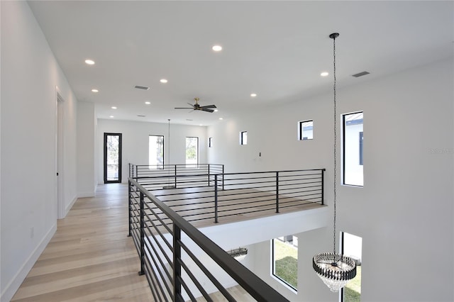 hall featuring an inviting chandelier and light hardwood / wood-style flooring