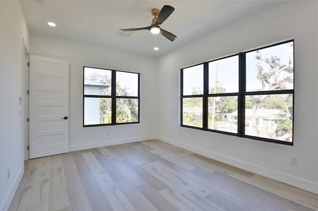 empty room with ceiling fan and light hardwood / wood-style flooring