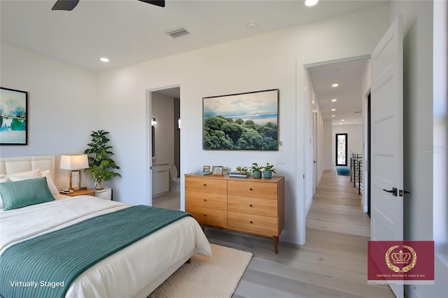 bedroom featuring light wood-type flooring and ensuite bath